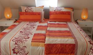 1 dormitorio con 2 camas con edredones de color naranja y blanco en Stadtnahe Komfortferienwohnung für Familien und Geschäftsreisende en Hildesheim