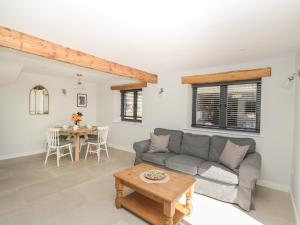 a living room with a couch and a table at Kingfisher, 2 The Old Stables in Witney