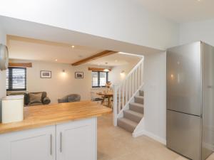 a kitchen and living room with a staircase at Swallows, 1 The Old Stables in Witney