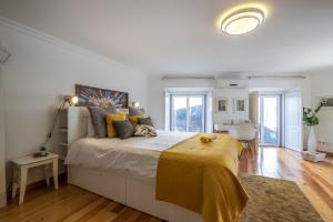 um quarto com uma cama grande com um cobertor amarelo em Lisbon City Center Baixa em Lisboa