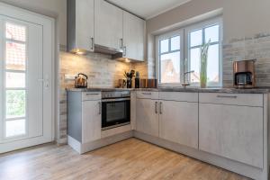a kitchen with stainless steel appliances and wood floors at EBBEUNFLUT in Sankt Peter-Ording