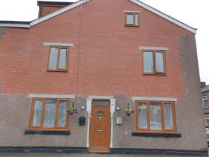 ein Backsteinhaus mit brauner Tür und Fenstern in der Unterkunft No 10 LimeHouse in Oldham