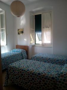 sypialnia z 2 łóżkami i 2 oknami w obiekcie ANTICO BORGO AL MARE w mieście Lavagna