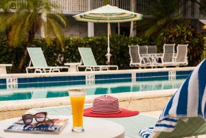 uma bebida sentada numa mesa ao lado de uma piscina em South Beach Place - Vero Beach em Vero Beach