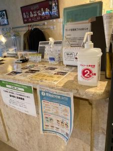 a counter with signs and a bottle of water on it at Hotel Platon in Chikuma