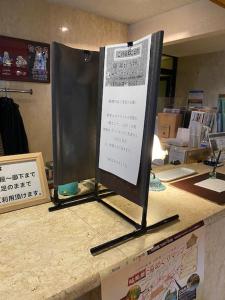 una señal sentada en la parte superior de un mostrador en Hotel Platon, en Chikuma