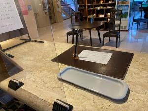 una encimera de cristal con mesa y sillas en una tienda en Hotel Platon, en Chikuma