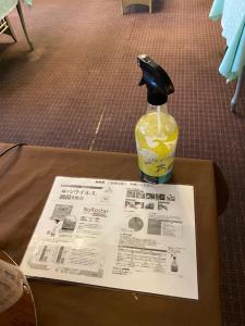 a newspaper and a bottle of drink on a table at Hotel Platon in Chikuma