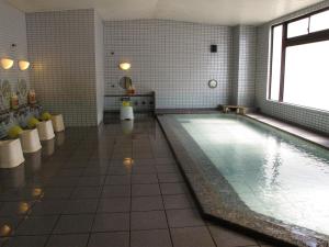 a large swimming pool in a room with at Hotel Platon in Chikuma