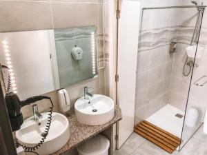 La salle de bains est pourvue d'un lavabo et d'une douche. dans l'établissement Urban Garden Porto Central Hostel, à Porto