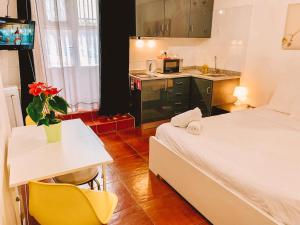 Cette petite chambre comprend un lit, une table et une cuisine. dans l'établissement Urban Garden Porto Central Hostel, à Porto