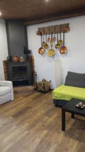 a living room with a green bed and a fireplace at Casa Rural Abuela Isabel in Guadalupe