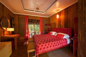 - une chambre avec un lit rouge et une fenêtre dans l'établissement Hotel Vila Naià - Corumbau, à Corumbau