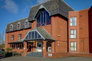 a red brick building with a black roof at The Hillcrest Hotel in Widnes
