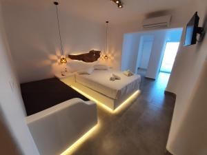 a bedroom with a bed and a tub with lights at Eternal Suites in Mýkonos City