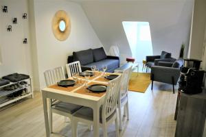 ein Esszimmer und ein Wohnzimmer mit einem Tisch und Stühlen in der Unterkunft Appartements Up & Down by Beds76 in Rouen