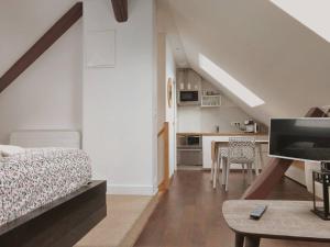 1 dormitorio con cama, mesa y cocina en Appartements Up & Down by Beds76, en Rouen