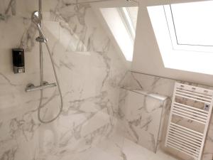 a bathroom with a shower with white marble at Appartements Up & Down by Beds76 in Rouen +20 photos