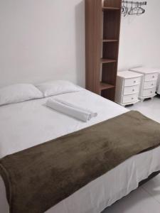 a bedroom with a large white bed with a dresser at Mar aberto suítes in Arraial do Cabo +70 photos