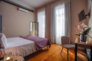 Un dormitorio con una cama, una mesa y una silla. en Palacete Suite Aveiro, en Aveiro 15 fotos más