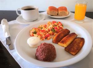 サン・サルバドルにあるHotel Armonía Hostalのコーヒーとテーブルの上に並ぶ朝食用の食品
