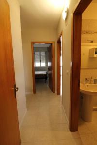 a hallway leading to a bathroom with a sink at Sabbia e Mare in Torre San Giovanni Ugento +39 photos