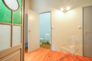 a white chair in a room with a bathroom at Palacete Suite Aveiro in Aveiro