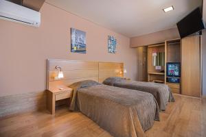 a hotel room with two beds and a flat screen tv at Hotel Botanico in Lisbon +32 photos