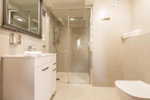 a white bathroom with a shower and a sink at Apartamenty Kupiecka ścisłe centrum in Zielona Góra +38 photos