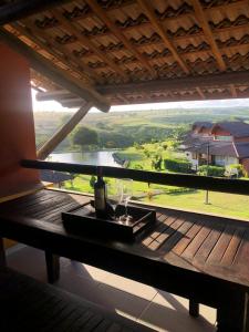 a balcony with a table with a view of a house at Winterville Resort em Gravatá/PE in Gravatá