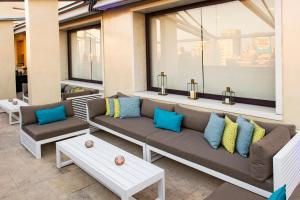a patio with a couch and pillows on it at Hotel Grand Brizo Buenos Aires in Buenos Aires
