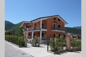 a large orange house with a fence in front of it at Stunning 2 Bed Apartment, Outside Terrace, Sleeps 4 in Villa Latina