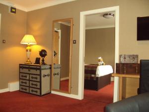 a room with a bedroom with a mirror and a dresser at Manchester South Hotel, Sure Hotel Collection by BW in Manchester