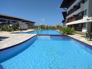 a large swimming pool next to a building at Cupe Beach Living Beira Mar - Flat 02 quartos in Porto De Galinhas