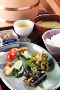 un plato de comida con verduras en una mesa en Dougoya en Matsuyama