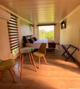 Schlafzimmer mit einem Bett, einem Tisch und Stühlen in der Unterkunft Hostería Ojo de Agua in Loreto