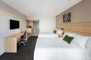 a hotel room with two beds and a desk at Crowne Plaza Queenstown, an IHG Hotel in Queenstown