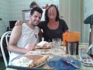 un hombre y una mujer sentados en una mesa comiendo comida en São Paulo Wanderlust G Hostel, en São Paulo