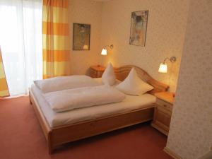 - une chambre avec un lit doté de draps et d'oreillers blancs dans l'établissement Haus Landl, à Haus im Ennstal