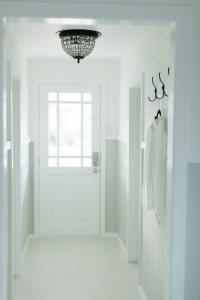 a white hallway with a door and a chandelier at The Rested Guest 3 Bedroom Cottage West Wyalong in West Wyalong