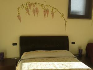 ein Schlafzimmer mit einem Bett mit einem Blumenbild an der Wand in der Unterkunft Agriturismo Botton D'Oro in Dongo