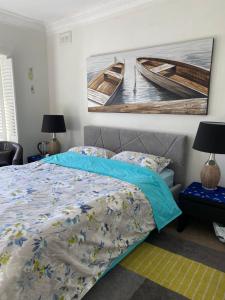 a bedroom with a bed and two boats on the wall at Seaside Home in Melbourne