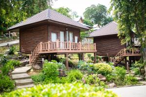 une cabane en rondins avec une terrasse et une maison dans l'établissement Phi Phi The Beach Resort, sur les Îles Phi Phi