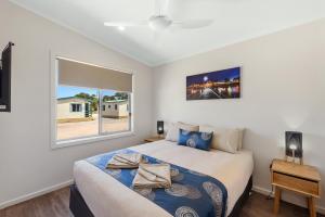a bedroom with a large bed and a window at Discovery Parks - Streaky Bay Foreshore in Streaky Bay