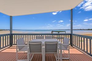 a patio with chairs and a table with a view of the ocean at Discovery Parks - Streaky Bay Foreshore in Streaky Bay
