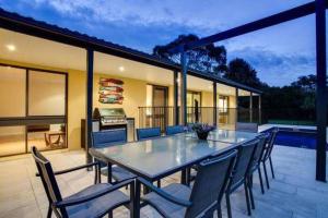 a table and chairs on a patio with a grill at Charmes, paradise by the shore in Tootgarook