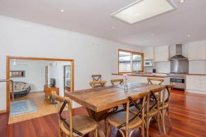 a kitchen and dining room with a wooden table and chairs at Charmes, paradise by the shore in Tootgarook +9 photos