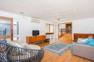 a living room with a couch and a tv at Charmes, paradise by the shore in Tootgarook