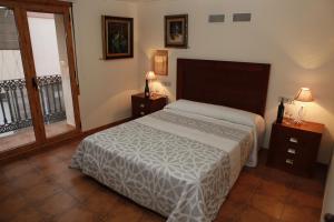 een slaapkamer met een bed, 2 tafels en een raam bij Casa Rural Magnanimvs in Vilafames