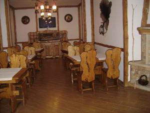 a dining room with tables and chairs and a chandelier at Glanz in Yaremche